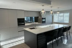 German Kitchen with grey cupboards, dark island with white worktop